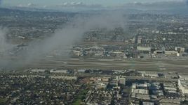 7.6K aerial stock footage approaching the airport, partially obscured by low level clouds, LAX, California Aerial Stock Footage | AX0161_044