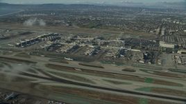 7.6K aerial stock footage approaching the airport as airlines taxi on the runways, LAX, California Aerial Stock Footage | AX0161_045E