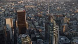7.6K aerial stock footage of a city sprawl beyond the tops of Aon Center and Wilshire Grand Center at sunset in Downtown Los Angeles, California Aerial Stock Footage | AX0162_081