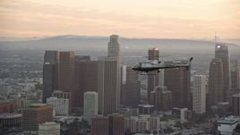 7.6K aerial stock footage tracking an LAPD helicopter flying by the skyline of Downtown Los Angeles, California at twilight Aerial Stock Footage | AX0162_092E