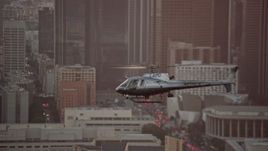 7.6K aerial stock footage tracking an LAPD helicopter flying by Downtown Los Angeles, California at twilight Aerial Stock Footage | AX0162_095E