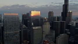 4K aerial stock footage of flying over a skyscraper reflecting the sunset, Downtown Chicago, Illinois Aerial Stock Footage | AX0163_0030