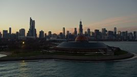 4K aerial stock footage flyby Shedd Aquarium, reveal Adler Planetarium, city skyline at twilight, Downtown Chicago, Illinois Aerial Stock Footage | AX0163_0045