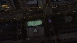 4K aerial stock footage a bird's eye of the ice skating rink by the Cloud Gate in Grant Park at twilight, Downtown Chicago, Illinois Aerial Stock Footage | AX0163_0051