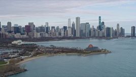 4K aerial stock footage of flying by Adler Planetarium, reveal Downtown Chicago skyline, Illinois Aerial Stock Footage | AX0165_0062