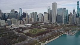 4K aerial stock footage of flying over Grant Park to approach Downtown Chicago skyscrapers, Illinois Aerial Stock Footage | AX0165_0064