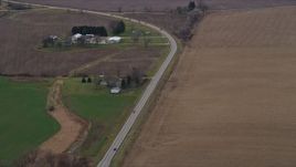 4K aerial stock footage of passing farmhouses by a country road in Bristol, Wisconsin Aerial Stock Footage | AX0166_0046