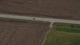4K aerial stock footage of a car traveling on a country road in Bristol, Wisconsin Aerial Stock Footage | AX0166_0047
