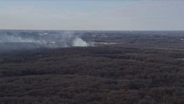 4K aerial stock footage of smoke rising from a fire in the forest, Willow Springs, Illinois Aerial Stock Footage | AX0168_0021