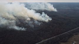 4K aerial stock footage of approaching plumes of smoke rising from fires in the forest, Willow Springs, Illinois Aerial Stock Footage | AX0168_0022