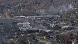 4K aerial stock footage of shops on 19th Street, smoke rising from trees, in Lockport, Illinois Aerial Stock Footage | AX0168_0029