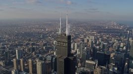 4K aerial stock footage of approaching the top of Willis Tower and tilting to a bird's eye view of the skyscraper, Downtown Chicago, Illinois Aerial Stock Footage | AX0169_0080