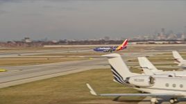 4K aerial stock footage of a Southwest jet taking off from Chicago Midway International Airport at sunset, Illinois Aerial Stock Footage | AX0169_0108