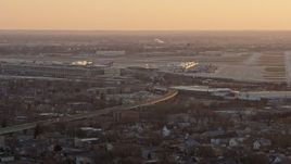 4K aerial stock footage of flying away from Chicago Midway International Airport at sunset, Illinois Aerial Stock Footage | AX0170_0003