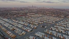 4K aerial stock footage tilt from train yard in Southwest Side to reveal distant Downtown Chicago skyline at sunset, Illinois Aerial Stock Footage | AX0170_0004