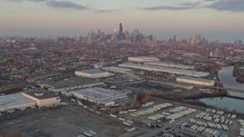 4K aerial stock footage the distant Downtown Chicago skyline seen from West Side warehouses at sunset, Illinois Aerial Stock Footage | AX0170_0006