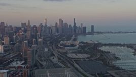 4K aerial stock footage wide view of the Downtown Chicago skyline, reveal Soldier Field at sunset, Illinois Aerial Stock Footage | AX0170_0011