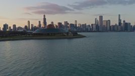 4K aerial stock footage fly past Adler Planetarium toward the Downtown Chicago skyline and Grant Park at sunset, Illinois Aerial Stock Footage | AX0170_0013