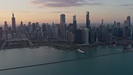 4K aerial stock footage reverse view of the Downtown Chicago skyline and Grant Park at sunset, Illinois Aerial Stock Footage | AX0170_0015