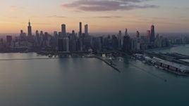 4K aerial stock footage reverse view of the Downtown Chicago skyline at sunset, reveal Navy Pier, Illinois Aerial Stock Footage | AX0170_0016