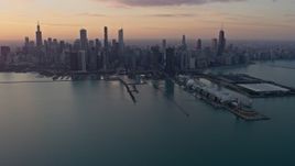 4K aerial stock footage slowly flyby Navy Pier to approach the Downtown Chicago skyline at sunset, Illinois Aerial Stock Footage | AX0170_0017