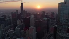4K aerial stock footage of Downtown Chicago skyscrapers with a view of the setting sun, Illinois Aerial Stock Footage | AX0170_0019