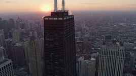 4K aerial stock footage of flying around John Hancock Center to reveal the setting sun, Downtown Chicago, Illinois Aerial Stock Footage | AX0170_0020