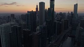 4K aerial stock footage focus on the setting sun while flying by skyscrapers in Downtown Chicago, Illinois Aerial Stock Footage | AX0170_0024