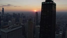 4K aerial stock footage focus on the setting sun while flying by John Hancock Center in Downtown Chicago, Illinois Aerial Stock Footage | AX0170_0025