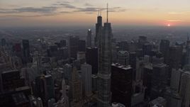 4K aerial stock footage focus on Willis Tower and fly past skyscrapers, reveal distant sunset, Downtown Chicago, Illinois Aerial Stock Footage | AX0170_0032