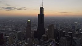 4K aerial stock footage fly over Willis Tower and reveal distant sunset, Downtown Chicago, Illinois Aerial Stock Footage | AX0170_0033