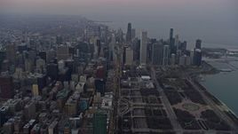 4K aerial stock footage of following Michigan Avenue by Grant Park toward skyscrapers at sunset, Downtown Chicago, Illinois Aerial Stock Footage | AX0170_0040