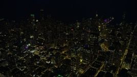 4K aerial stock footage of flying by downtown skyscrapers, some with holiday lights at night, Downtown Chicago, Illinois Aerial Stock Footage | AX0170_0071