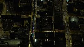 4K aerial stock footage of an L Train with holiday lights traveling at night, Downtown Chicago, Illinois Aerial Stock Footage | AX0170_0075
