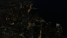 4K aerial stock footage of passing by downtown skyscrapers, some with holiday lights at night, Downtown Chicago, Illinois Aerial Stock Footage | AX0170_0077
