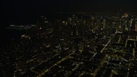 4K aerial stock footage a view of downtown skyscrapers, some with holiday lights at night, Downtown Chicago, Illinois Aerial Stock Footage | AX0170_0083