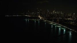 4K aerial stock footage of the city's skyline seen from near North Avenue Beach at night, Downtown Chicago, Illinois Aerial Stock Footage | AX0170_0090
