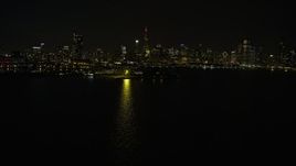 4K aerial stock footage fly past Adler Planetarium toward the city's skyline at night, Downtown Chicago, Illinois Aerial Stock Footage | AX0170_0096