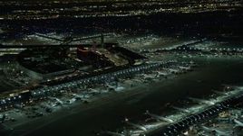4K aerial stock footage a reverse view of the terminals at O'Hare International Airport at night, Chicago, Illinois Aerial Stock Footage | AX0170_0113