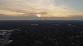 6.7K aerial stock footage of the distant Atlanta skyline, tilt to homes in Decatur at sunset, Georgia Aerial Stock Footage | AX0171_0139