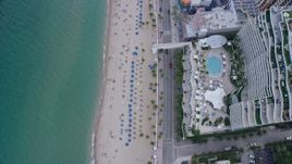 6.7K aerial stock footage of tilting to a bird's eye view of sunbathers on the beach in Fort Lauderdale, Florida Aerial Stock Footage | AX0172_062