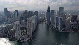 6.7K aerial stock footage of following the Miami River past waterfront skyscrapers in Downtown Miami, Florida Aerial Stock Footage | AX0172_107