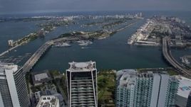 6.7K aerial stock footage tilt from skyscrapers in Downtown Miami, Florida, reveal islands in the bay Aerial Stock Footage | AX0172_116