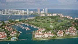 6.7K aerial stock footage ascend by Fisher Island oceanfront condo complexes, reveal golf course, Miami, Florida Aerial Stock Footage | AX0172_129