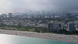 6.7K aerial stock footage of flying by South Beach, Florida with the Miami skyline in the distance Aerial Stock Footage | AX0172_142