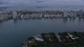 6.7K aerial stock footage tilt from Biscayne Bay to reveal and approach Miami Beach at sunset, Miami, Florida Aerial Stock Footage | AX0172_194
