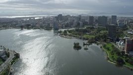 6K aerial stock footage tilt from homes to reveal and fly over Lake Merritt toward downtown, Oakland, California Aerial Stock Footage | AX0173_0014