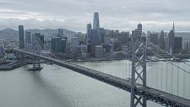 6K aerial stock footage flying beside the Bay Bridge with a view of Downtown San Francisco skyline, California Aerial Stock Footage | AX0173_0034