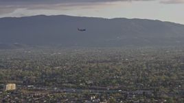 6K aerial stock footage of a commercial airplane flying over San Jose at sunset, California Aerial Stock Footage | AX0174_0030