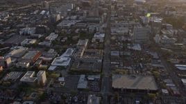 6K aerial stock footage of a reverse view of city street and office and apartment buildings in Downtown San Jose at sunset, California Aerial Stock Footage | AX0174_0039